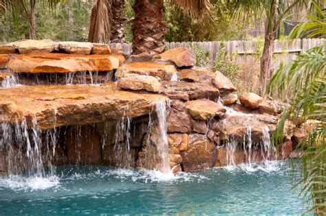 A natural stone stacked waterfall with water running off nearly every ...