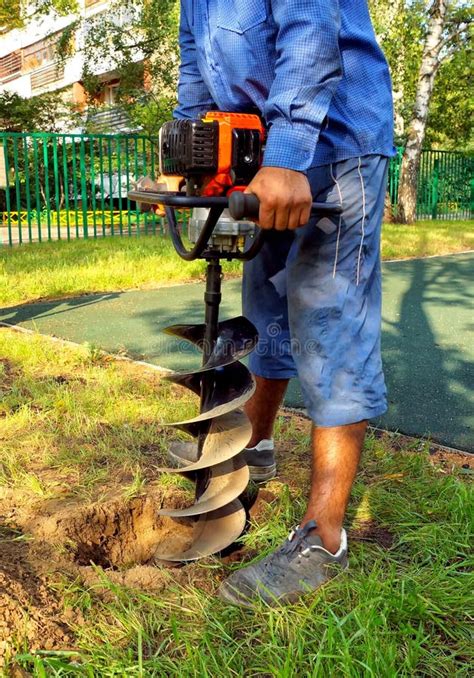 Worker Drilling Hole In The Ground Stock Photo - Image of hand, grass ...