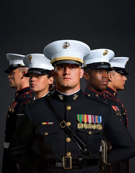 A group of Marines are shown in Dress Blues, their medals illuminated ...