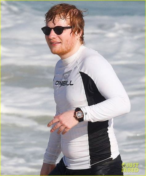 a man in a wet suit running on the beach