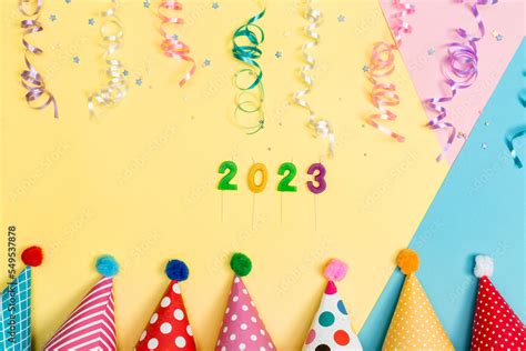 2023 party theme with with hats and streamers on a vibrant background ...