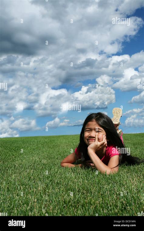 Little girl lying on grass Stock Photo - Alamy