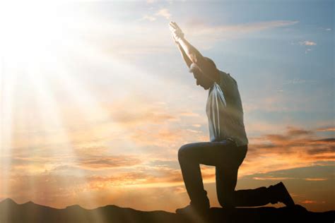 Silhouette Of A Man Kneeling And Praying On Mountain Stock Photos ...