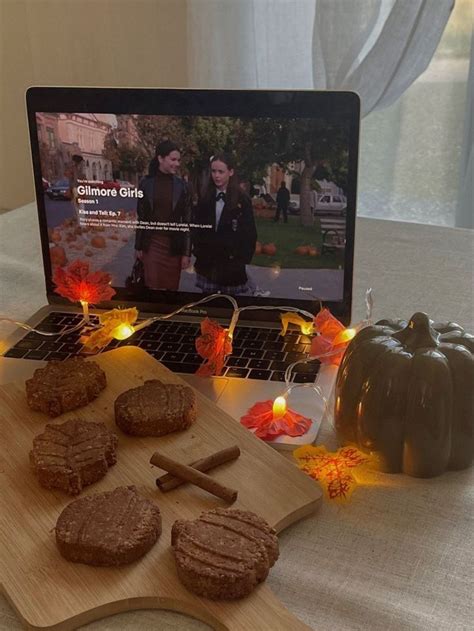 a laptop computer sitting on top of a wooden table next to cookies and ...