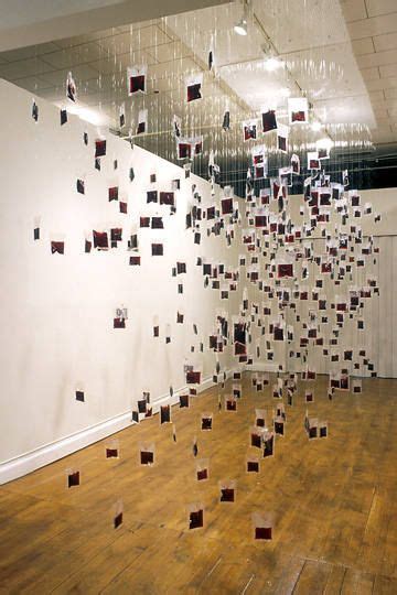 a room filled with lots of square pieces of art hanging from the ...