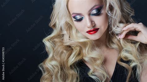 Portrait of a young luxurious blonde with long curls. Stock Photo ...