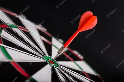 Premium Photo | Darts board with red dart arrow on center of dartboard.