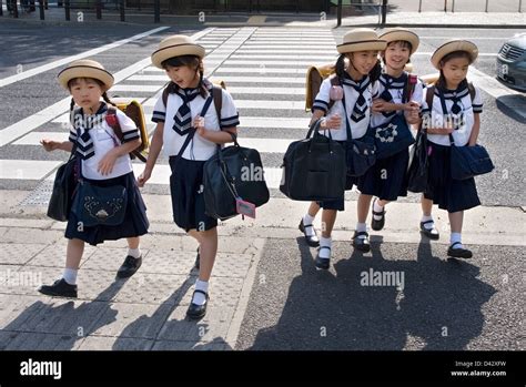 Five elementary school girls in sailor uniforms and cute hats crossing ...