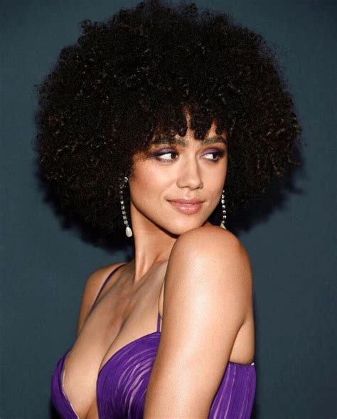 a woman in a purple dress with an afro hairstyle and large earrings on ...