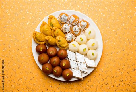 Indian sweets in a plate includes Gulab Jamun, Rasgulla, kaju katli ...