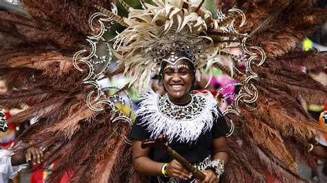 Notting Hill revellers dance in fabulous feather outfits as they hit ...