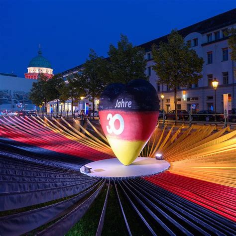 an artistic display in the middle of a city at night with lights and ...