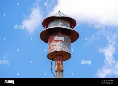 Old tornado siren in small Midwest town with blue skies and clouds in ...