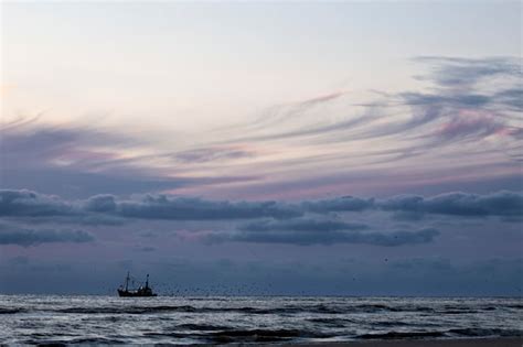 Premium Photo | Fishing ship in sea and sunset sky