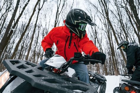 Premium Photo | Two people are riding atv in the winter forest