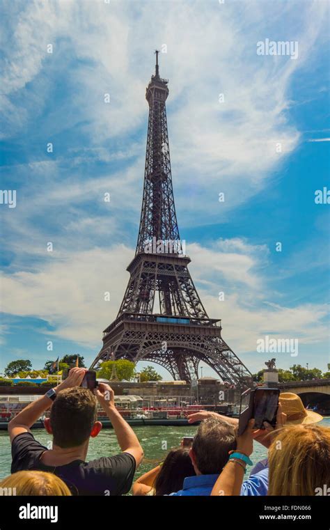 Tourist photographing Eiffel Tower from river cruise boat on Seine ...