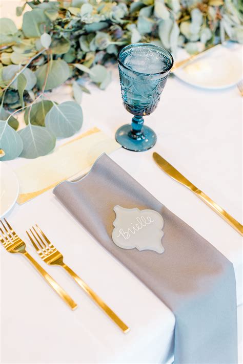 Place setting with gold flatware and a blue water goblet Photo: Gaby J ...