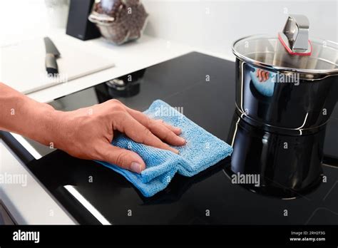 Woman cleaning induction stove. Modern kitchen with induction hob Stock ...