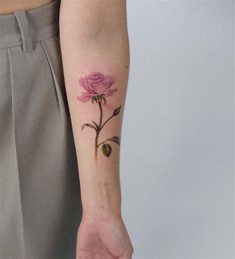 Watercolor pink rose tattoo on the inner forearm.