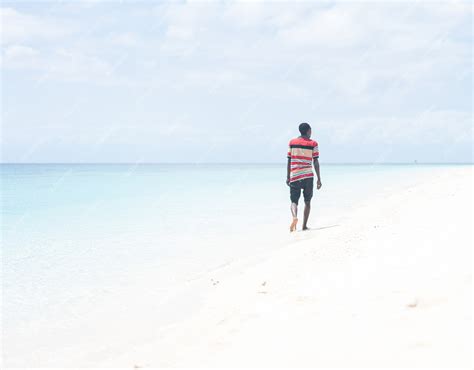 Premium Photo | Black african young man walking on the beach