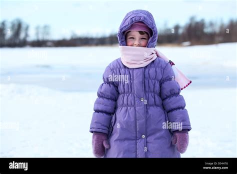 Wrapped in warm clothes small child standing outdoor in winter season ...