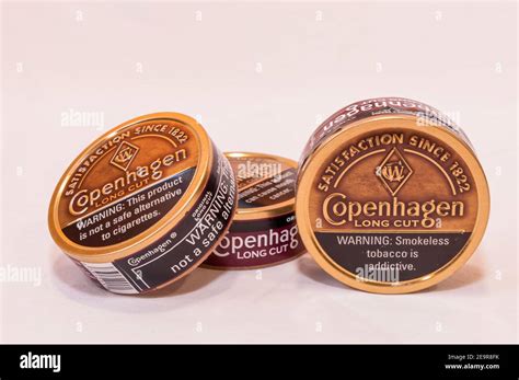 Three cans of Copenhagen Long Cut smokeless snuff tobacco on a white ...