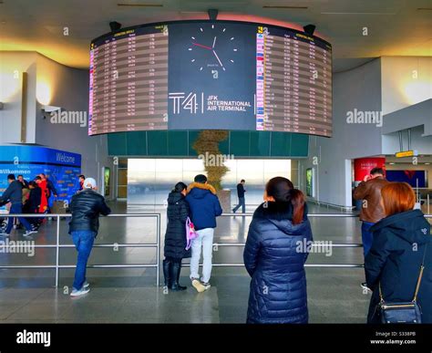 The arrival and departure board in terminal four at JFK airport, NYC ...