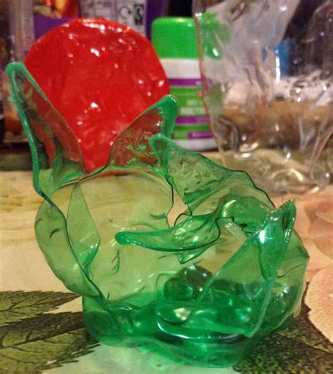 a green glass vase sitting on top of a table next to a red heart shaped ...