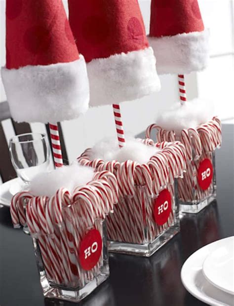 candy canes with santa hats on them are sitting in glass holders at the ...