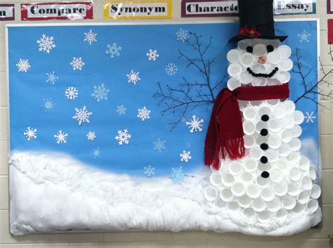 a snowman made out of paper plates sitting in front of a blue ...