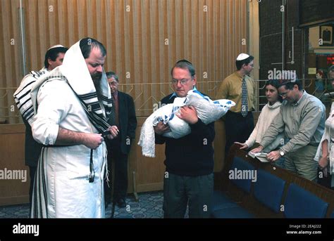 A Brit Milah ceremony takes place on the bimah of the synagogue in the ...