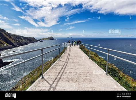 Hiking trail with railing on cliff, Skellig Islands on the horizon ...