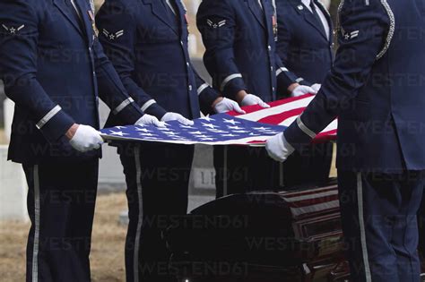 Soldiers folding flag at military funeral stock photo