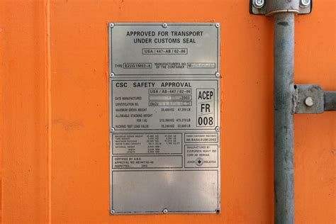 a metal sign on an orange wall that says approval for transport under ...