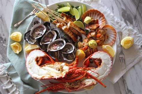 Seafood platter with fresh lobster, oysters, charred lime prawns and ...