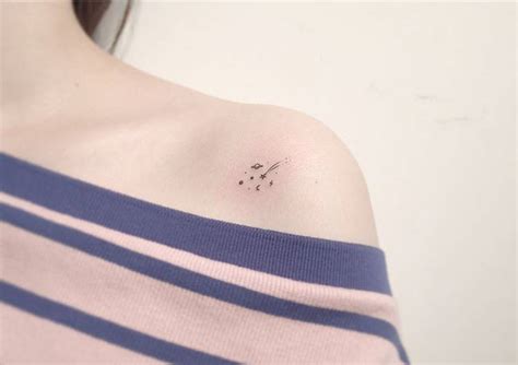 Minimalist space tattoos on the shoulder.