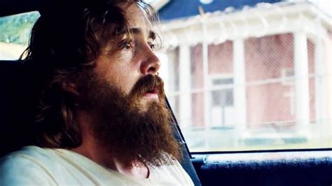 a man sitting in the back seat of a car with a long beard and wearing a ...