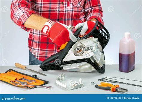 Serviceman is Repairing a Chainsaw in Repair Shop. Stock Image - Image ...