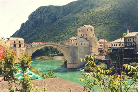 Stari Most Bridge Over River By Grassy Mountain Stock Photo | Adobe Stock