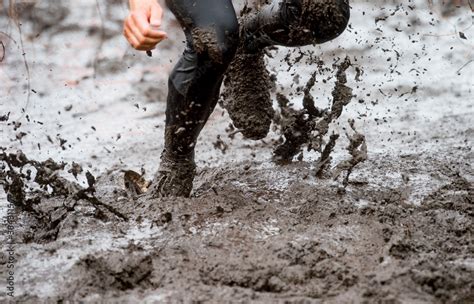 Mud race runner, man running in mud. Runners during extreme obstacle ...