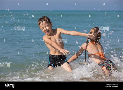 Happy children playing on the beach at the day time. Two Kids having ...