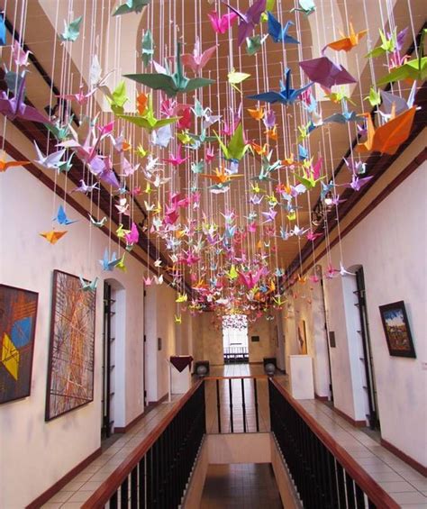 the ceiling is decorated with colorful origami birds hanging from it's ...