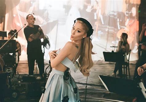 a woman with long hair standing in front of a group of musicians and ...