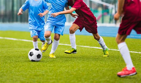 Young soccer players running towards soccer ball. Football soccer game ...