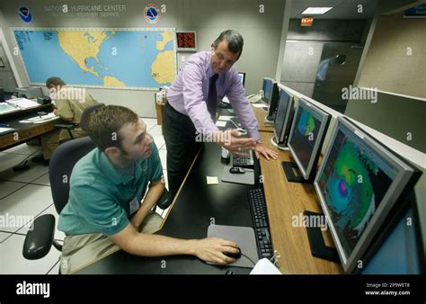 National Hurricane Center director Bill Read, center, talks with ...