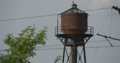 A Water Tower of 1950S Surrounded With Green Trees and One Electric ...