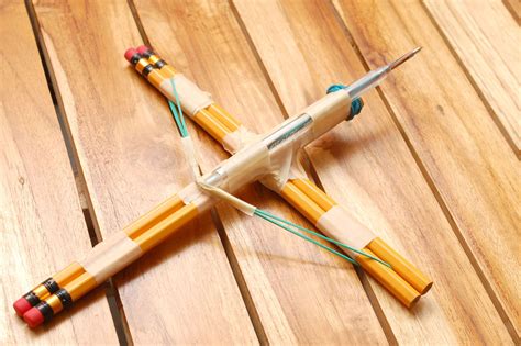 two pencils are laying next to each other on a wooden floor with an ...