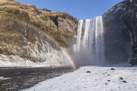 Iceland, Skogafoss waterfall with rainbow in winter stock photo