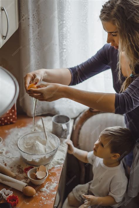 Free Photo | Little boy in the kitchen helps mom to cook. the child is ...