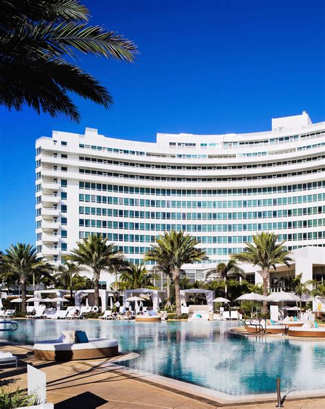 the hotel and pool are surrounded by palm trees